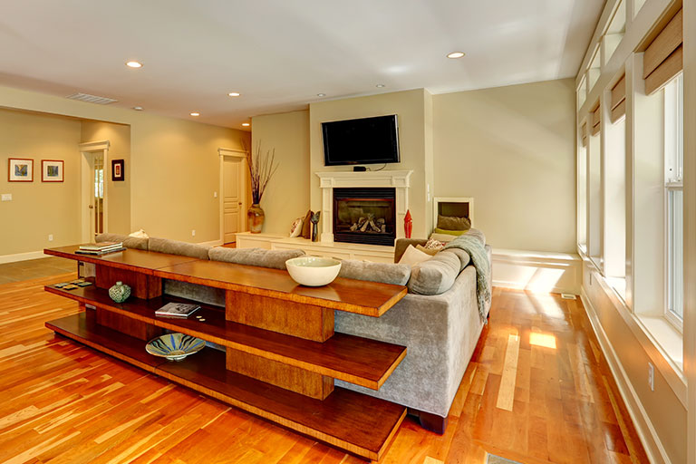 Luxury living room with fireplace and TV. View of couch and three level table set behind it